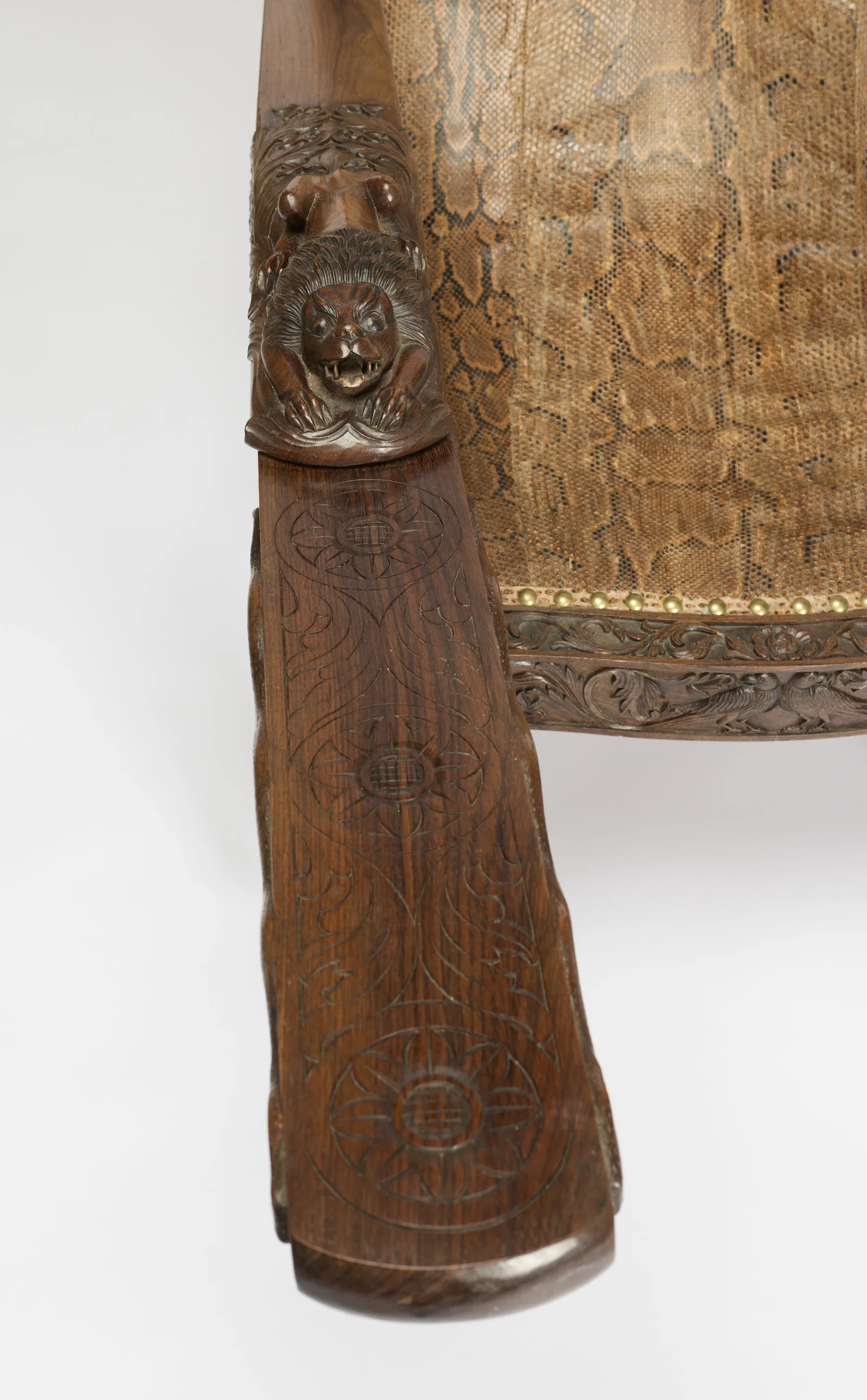 The swing-out board carries three incised flowerhead roundels along its length, the lion terminal at its head.