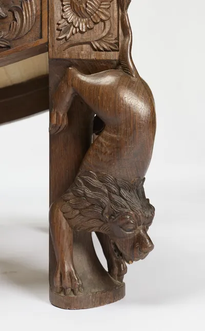 The descending beast's mane cut in deep relief; small losses are visible around the open mouth.