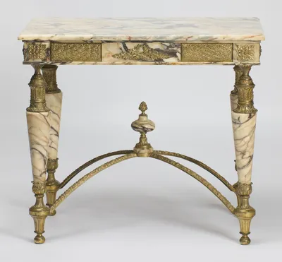 The bevelled veined top over gilt lattice panels and the central wreath mount, on tapering marble legs joined by the arched stretcher and its urn finial.