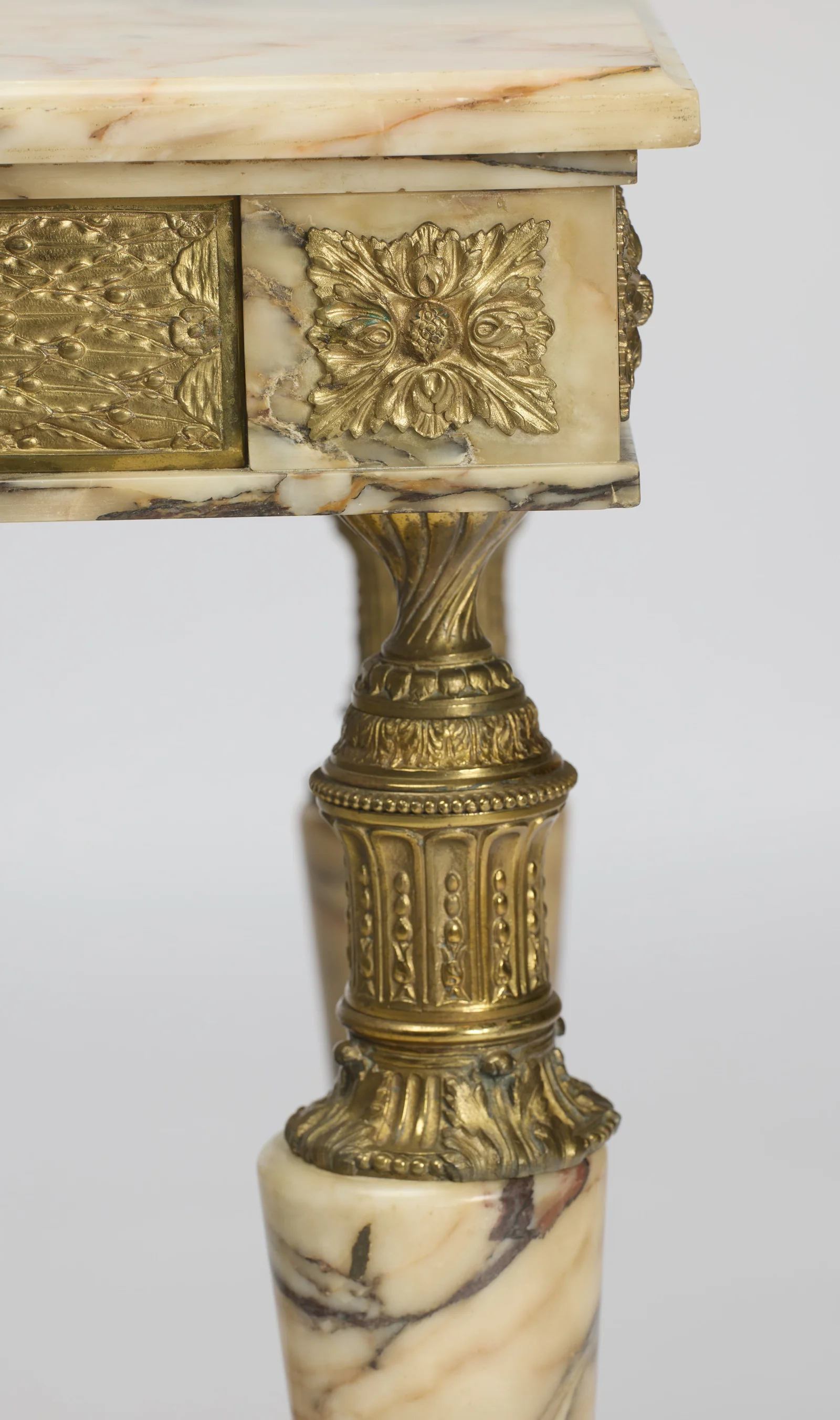 A square gilt block of layered leaves and berries beside an embossed panel of berried lattice-work.