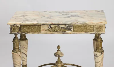 Grey, rust and blush veining running across the slab above the full run of gilt panels and the finial below.