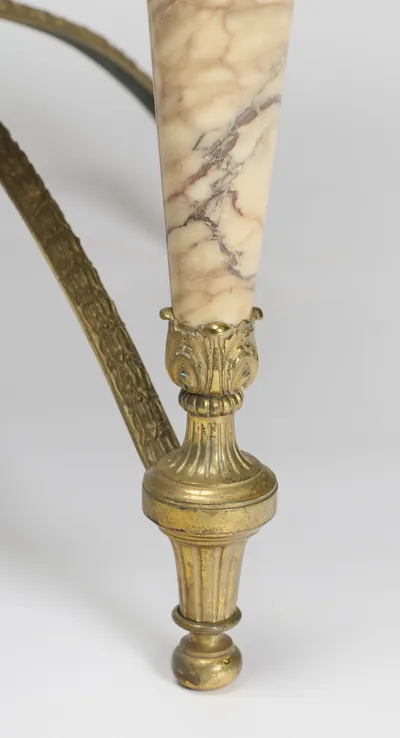 The veined taper of the leg falling through an acanthus cup to the fluted foot, one stretcher arm sweeping behind.