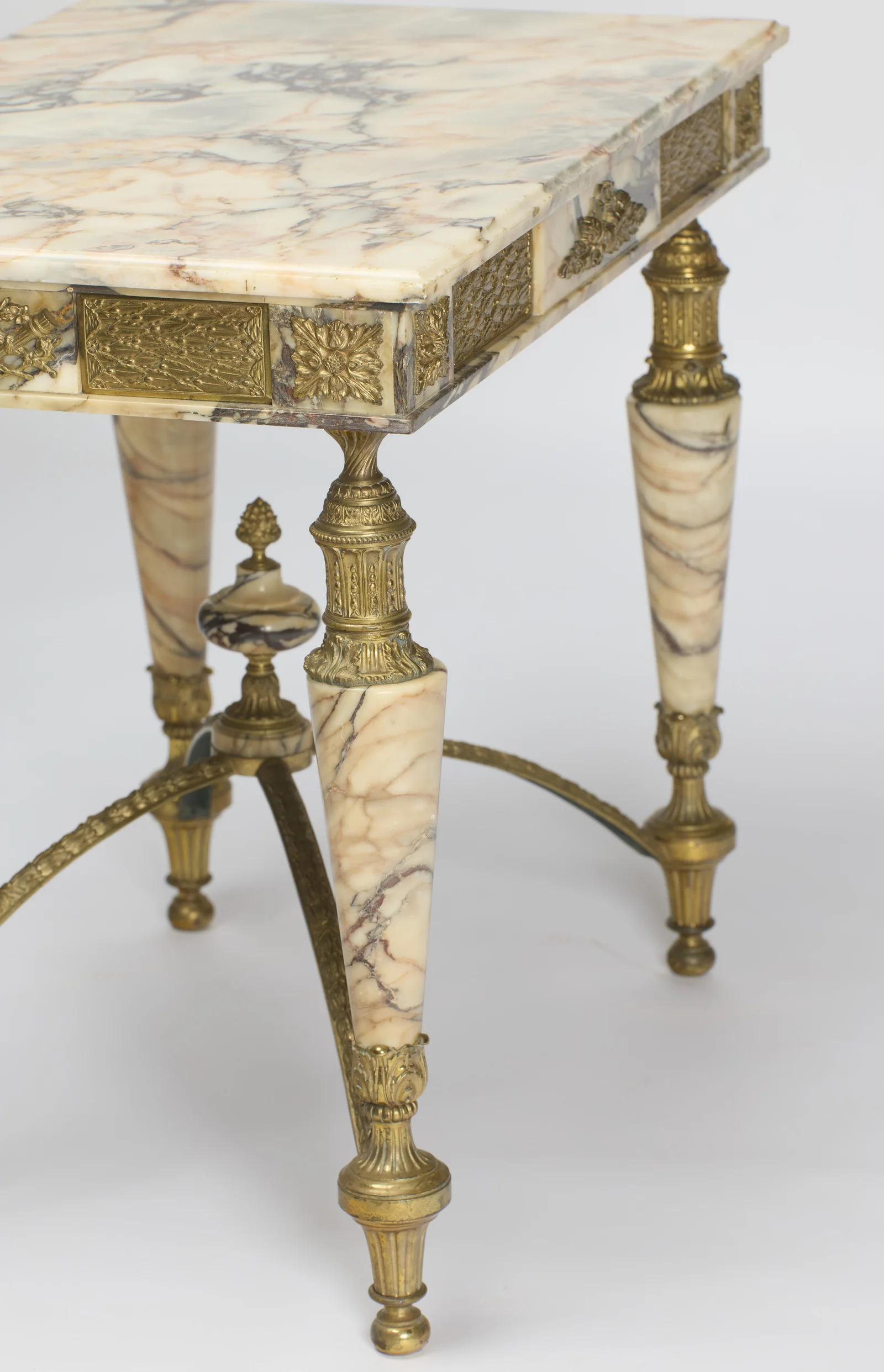 Frieze panels meeting at a corner rosette above one leg, the stretcher and finial beyond.