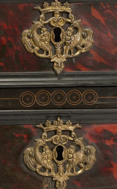 Two keyhole plates cast as paired birds beneath a crown, set on mottled red panels divided by a band of circle inlay.