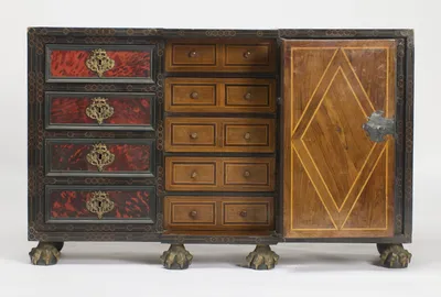 The central door stands open on five small drawers with line inlay and turned wood knobs, its inner face inlaid with a diamond and fitted with a shaped iron plate at the edge.