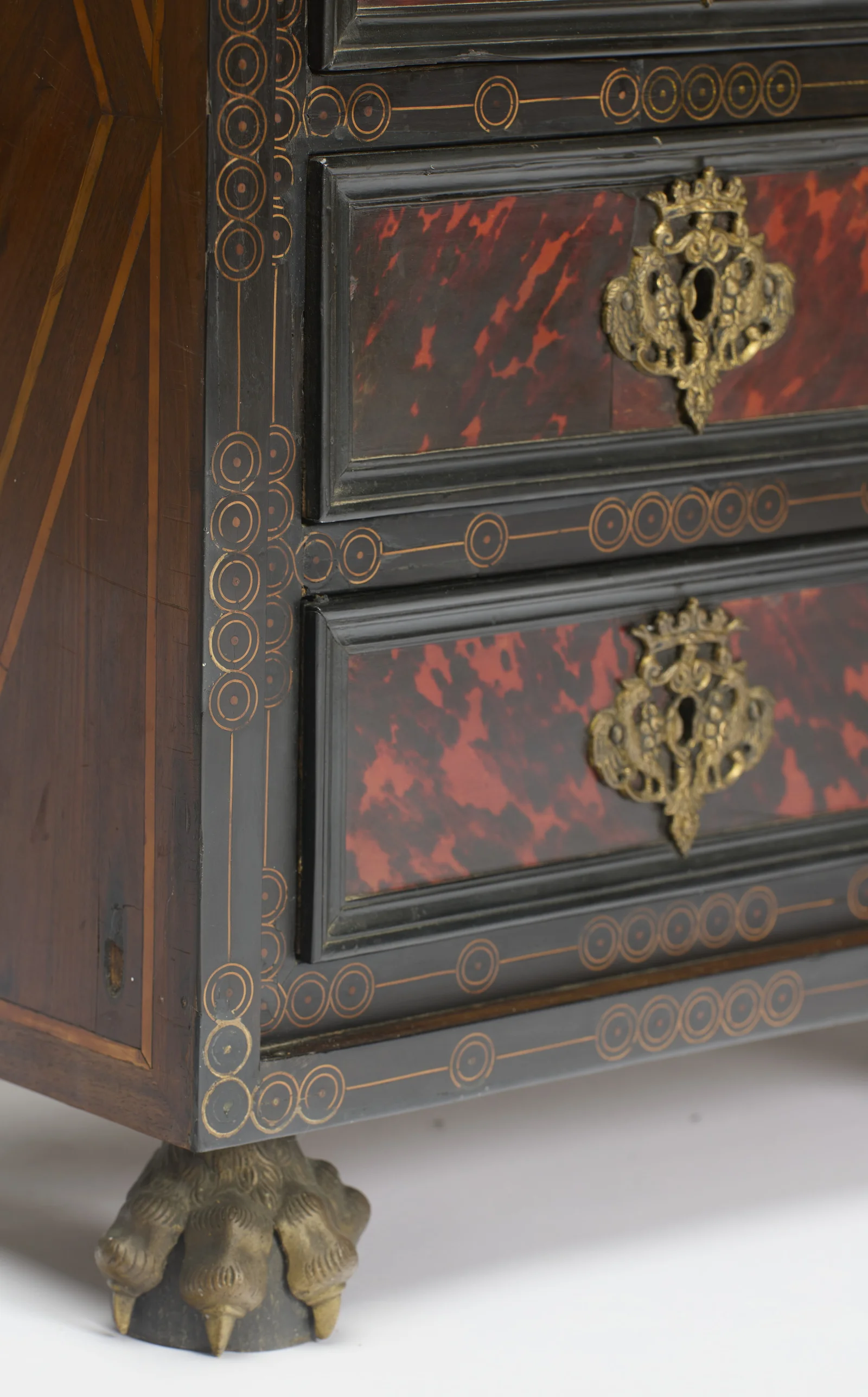 Chains of circle-and-dot inlay border the drawer fronts where they meet the rayed line inlay of the side, above a clawed paw foot.