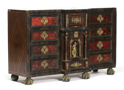 The left side carries a tall diamond of line inlay, meeting the circle-and-dot borders that frame every drawer on the front.