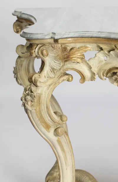 The corner seen from the side, following the shaped marble edge down through the scrolled bracket into the cabriole leg.