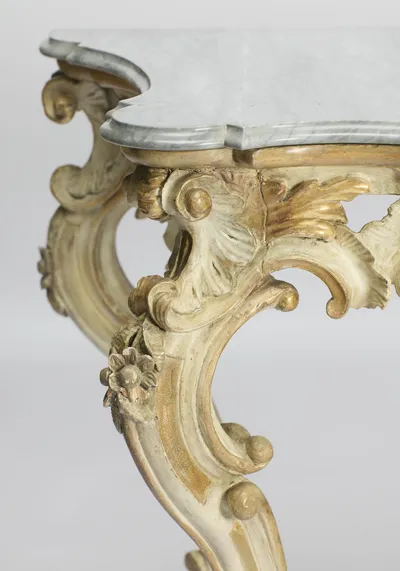 The serpentine corner of the marble seen from above, the scrolled knee brackets curving away beneath it.