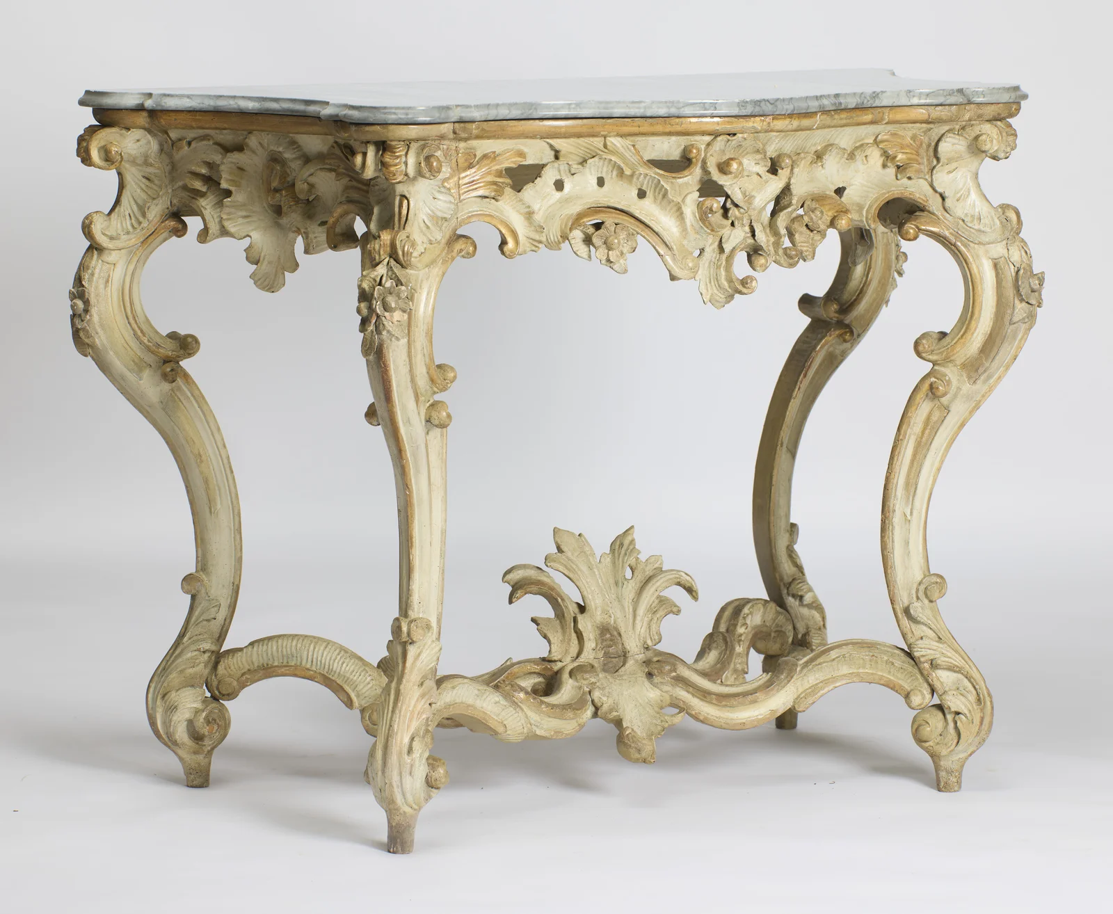 Angled view showing the depth of the shaped top and the carved apron returning along the right side over the legs.