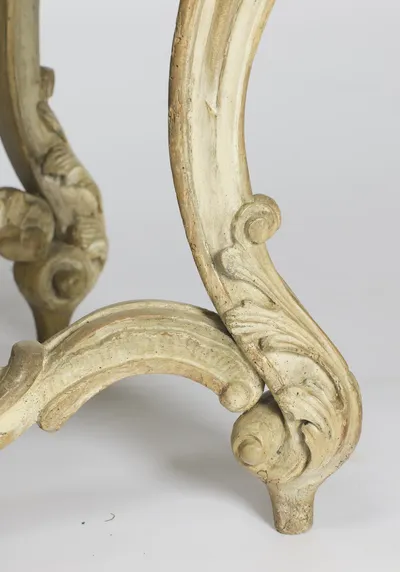 A front scroll foot with the ribbed stretcher curving behind, the paint worn through on the high points.