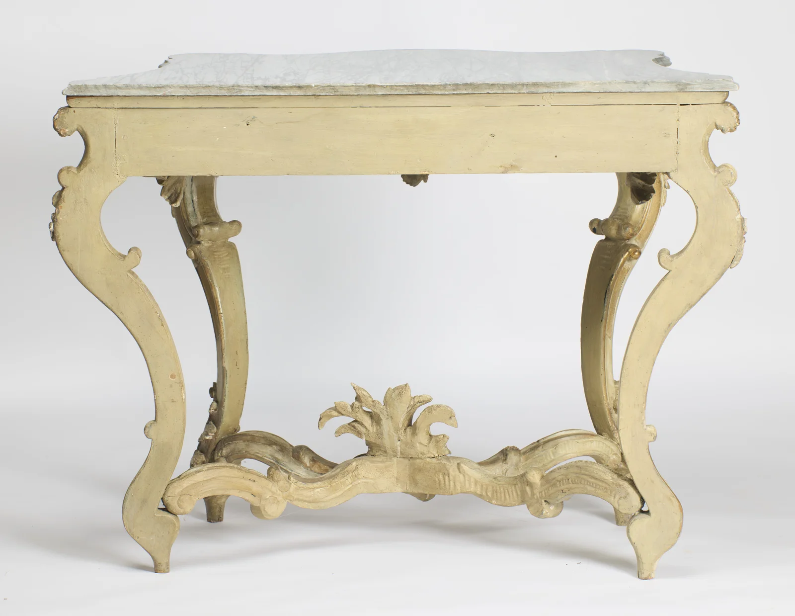 The plain painted back rail and flat-backed rear legs, with the marble overhanging and the stretcher plume seen from behind.
