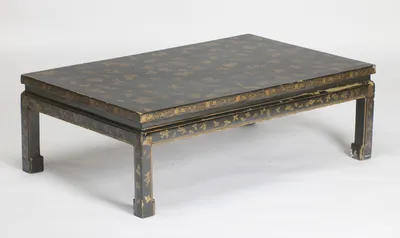 The low rectangular table with its gilt-scattered top, deep scrolling border and sprig-painted apron, raised on square-section legs with scrolled block feet.