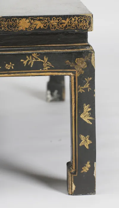 Flower heads and leaf sprigs inside the gilt border of the leg, with wear and small losses at the foot.