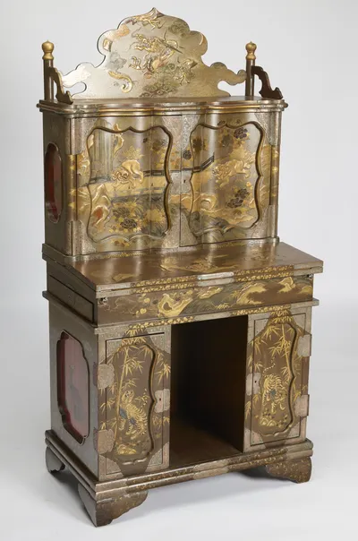 The stepped form seen at an angle, with shaped red reserves set into the side and the writing section projecting above the kneehole.