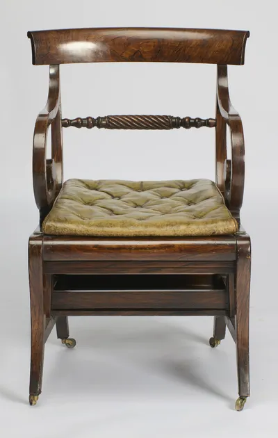 The curved crest rail spans scrolled supports above the spiral-turned cross rail and the buttoned squab cushion.