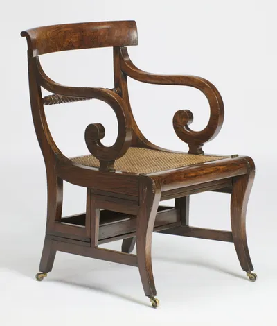 The cane seat seen three-quarter on, the seam of the folding frame running beneath the seat rail.