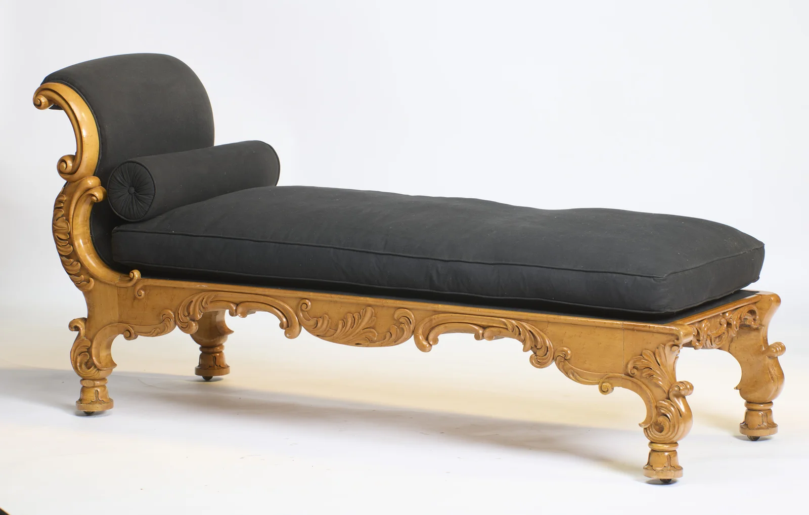 The carved apron and bracket legs run the full length of the seat, with the scrolled head end rising beyond.