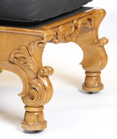 The S-scroll bracket leg is carved with sweeping leaves and ends in a turned, lappet-carved foot on a small castor.