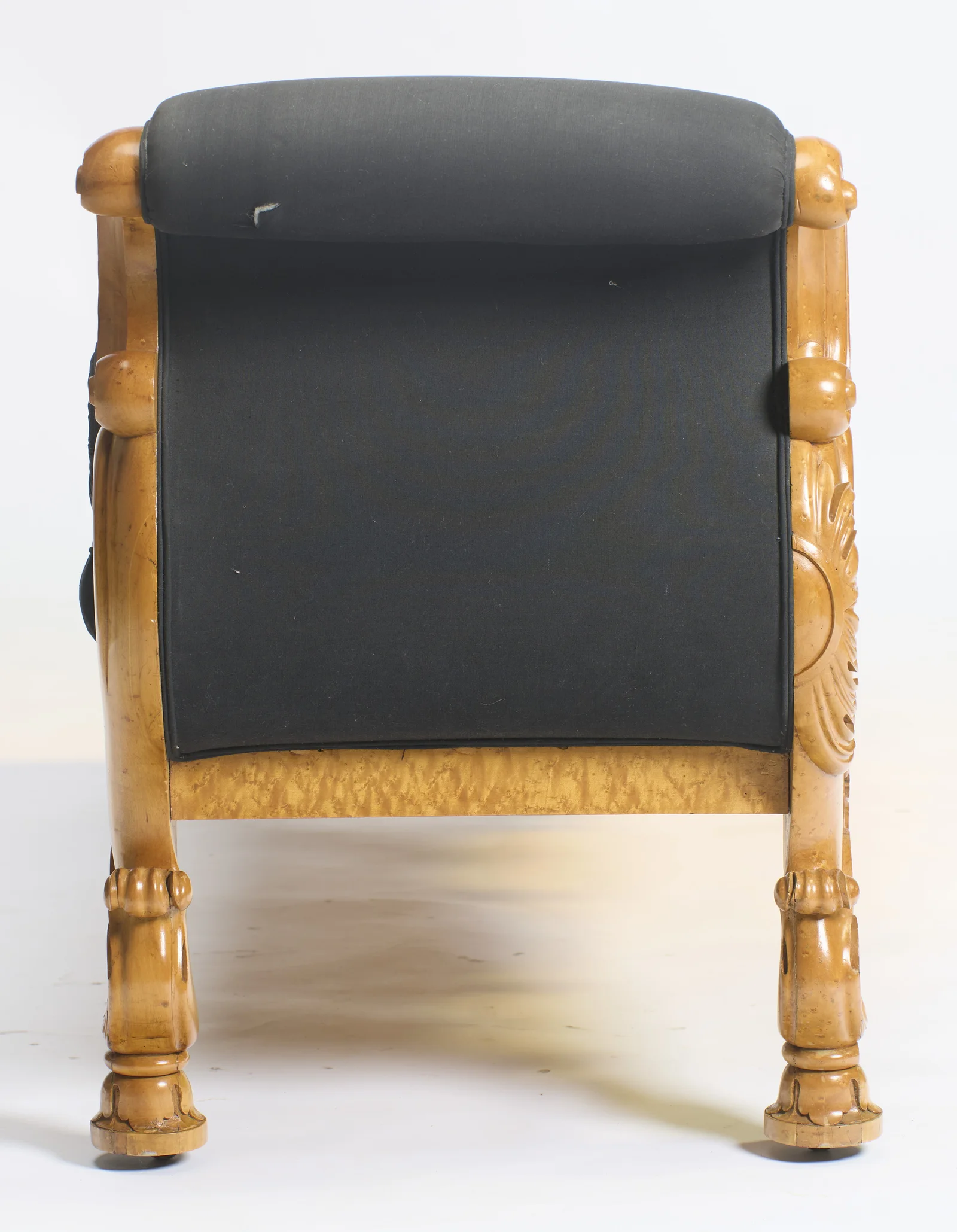 A flat panel of black cloth fills the space between two carved uprights, each finishing in a leafy roundel, on turned feet with castors.