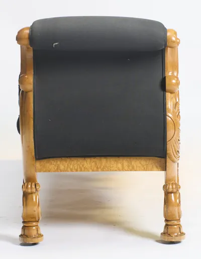 A flat panel of black cloth fills the space between two carved uprights, each finishing in a leafy roundel, on turned feet with castors.