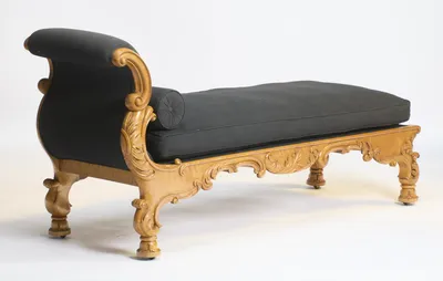 The outside of the scroll is covered in black cloth and framed by carved volutes, with the length of the bed beyond.