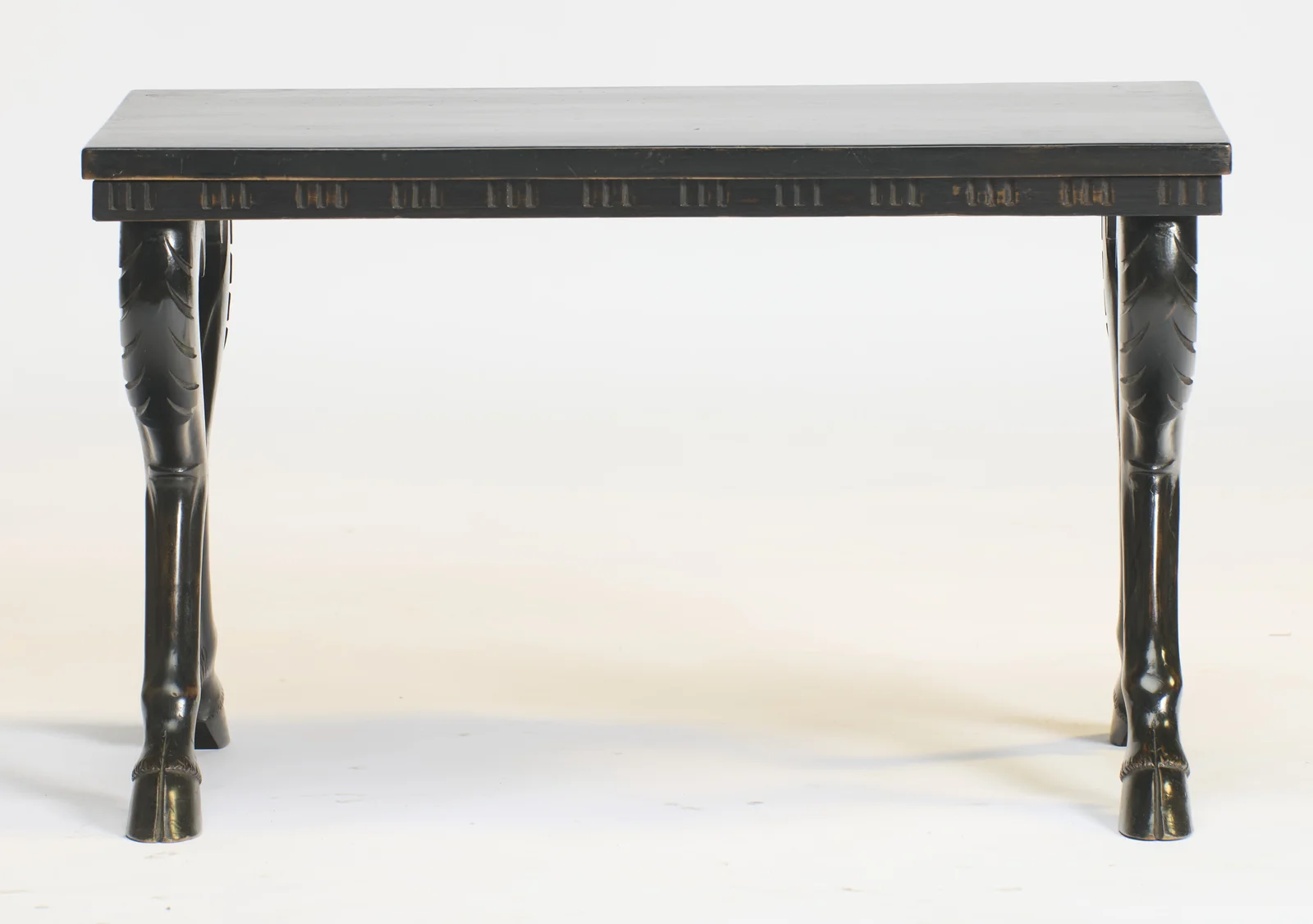 Straight on, the long frieze shows evenly spaced groups of short vertical flutes, the legs curving outward to hoofed feet at each corner.