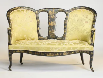 Arched back panels of unequal height flank the pierced centre splat, painted in gilt with figures and pavilions, above a serpentine seat rail and swept legs on castors.