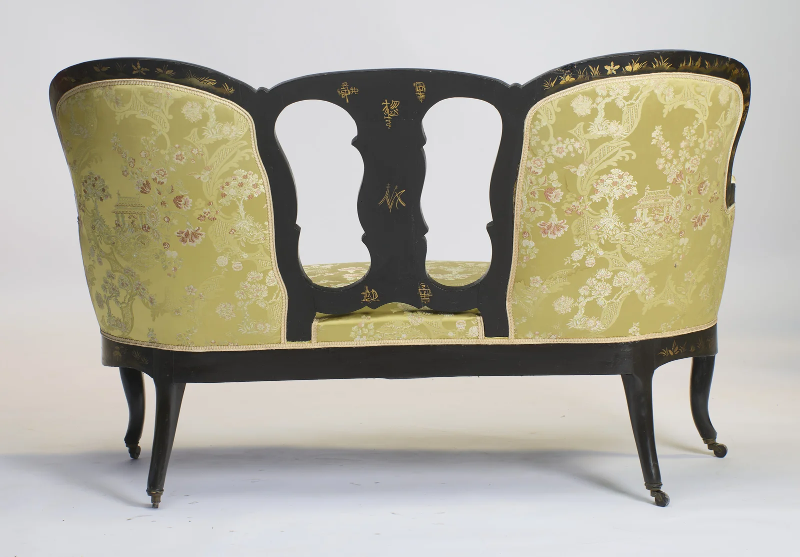 Gilt character-style marks decorate the reverse of the pierced splat, between two fully upholstered outside backs.
