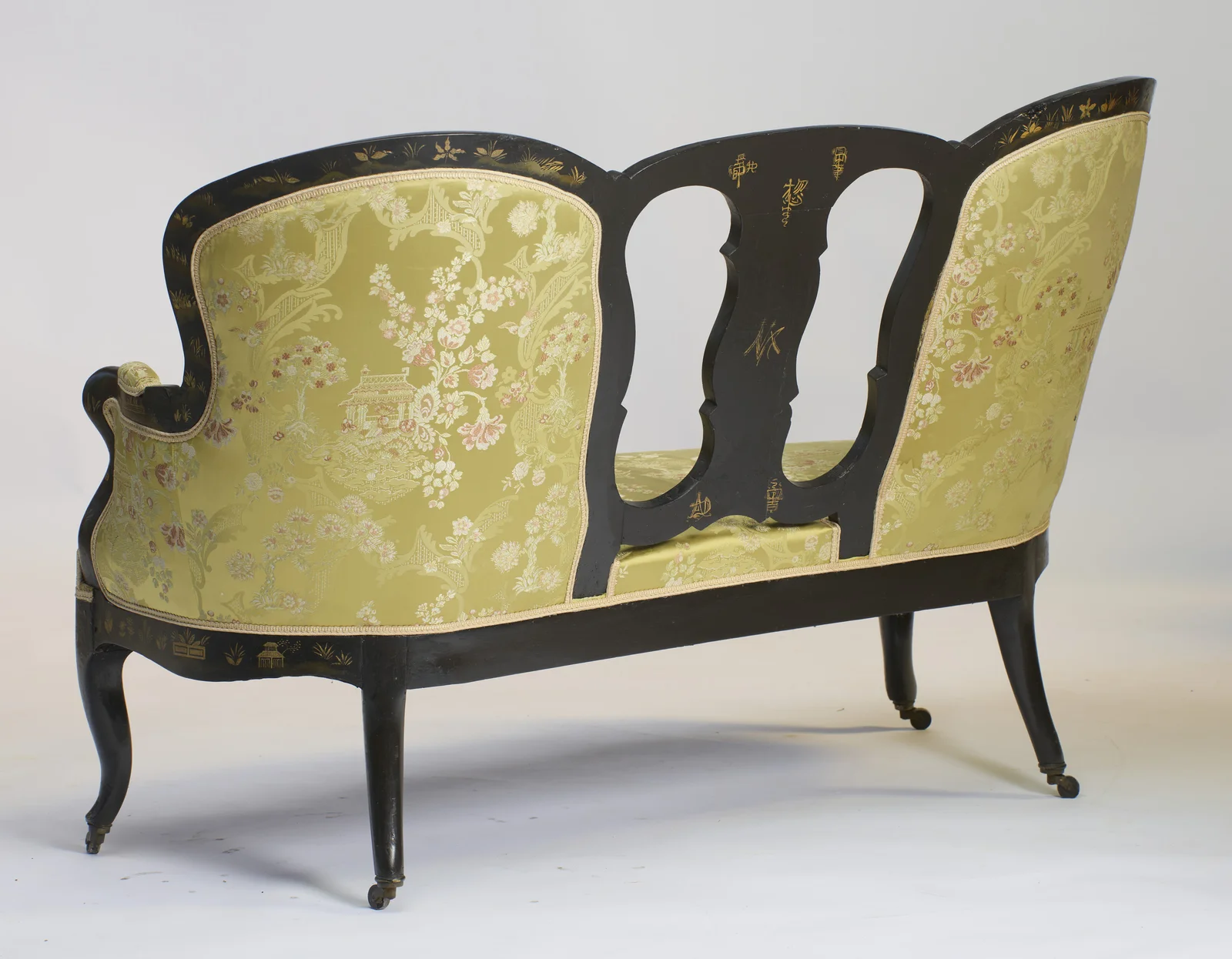 The upholstered outside back and swept rear legs, with the gilt marks visible on the splat.