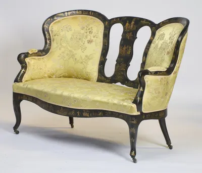 The taller back with its small elbow pad stands nearest, the damask seat sweeping away to the scrolled arm.