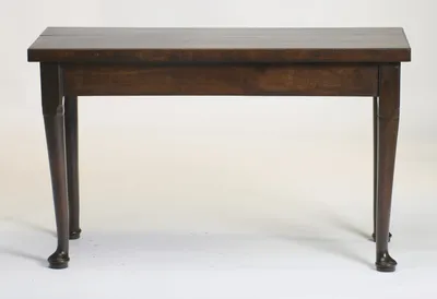 The long side face on, the plain frieze running between turned tapering legs that finish in pad feet raised on turned discs.