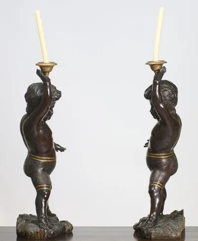 In profile the stride opens fully, the raised arm carrying the gilt nozzle above the head while the free hand extends behind.