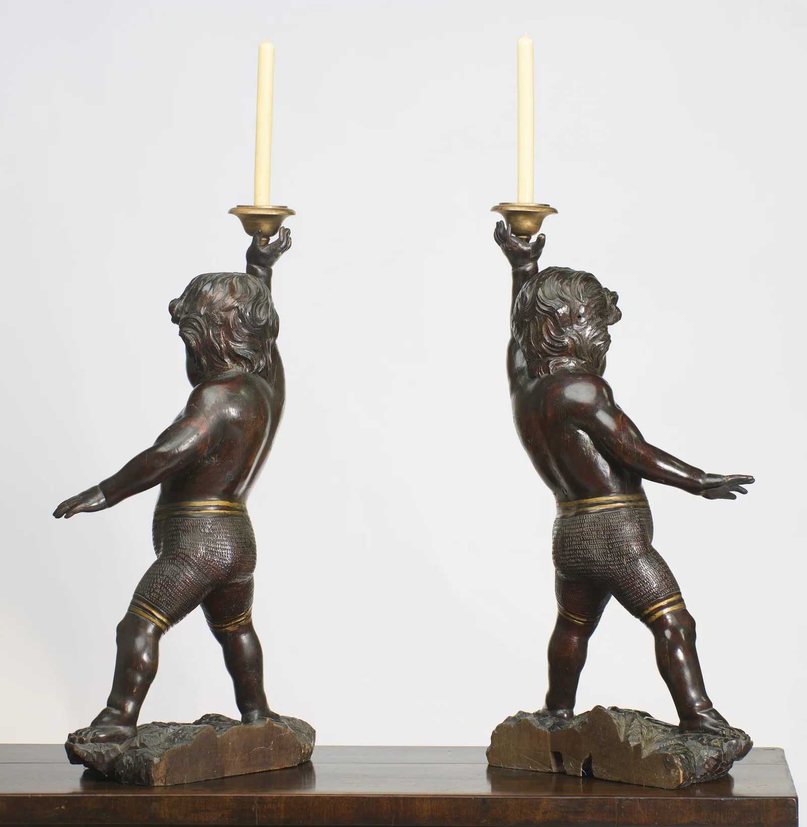 The figures lean into their stride, the outswung arm reaching back with fingers spread and the punched trunks continuing round.