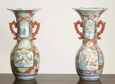 The principal body panels, a long-tailed bird among flowering branches on one vase and a bird perched in red-leafed boughs above rockwork and water on the other.