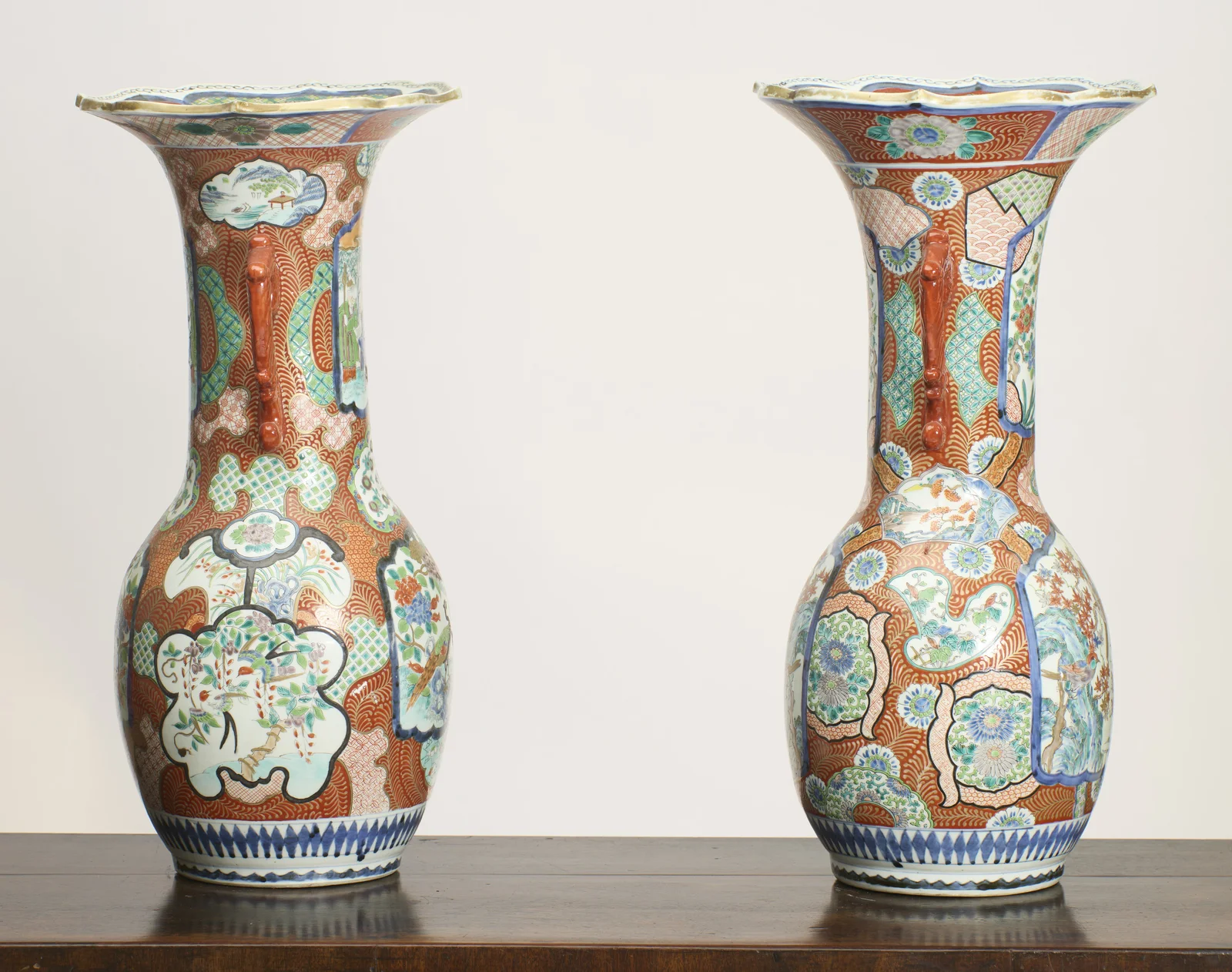 The scroll handles in profile, with the panelled decoration of flowers, birds and landscape vignettes carrying right around the neck and shoulder of each vase.