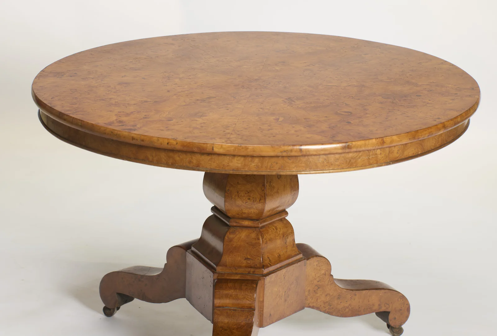 The burr top laid in segments meeting at the centre, with a moulded edge and deep frieze above the faceted baluster.
