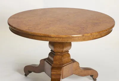 The burr top laid in segments meeting at the centre, with a moulded edge and deep frieze above the faceted baluster.
