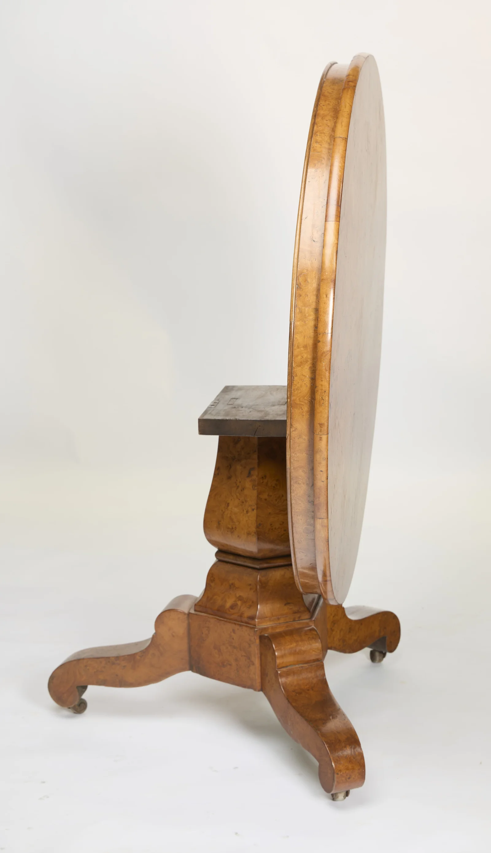 In profile the tilted top stands edge-on above the square bearer block, the baluster pedestal and the scroll legs.