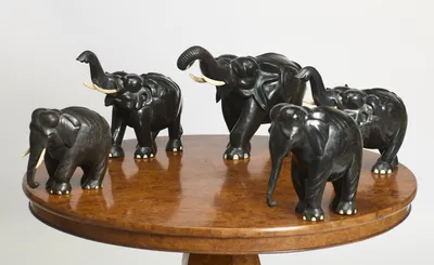 The five elephants spaced around the burr top, trunks variously raised, curled and lowered.