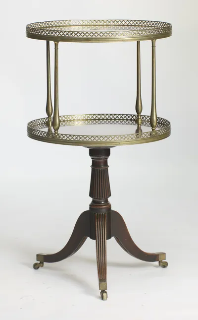 Both oval tiers with their pierced galleries, carried on baluster uprights over a reeded pedestal and three downswept legs on castors.