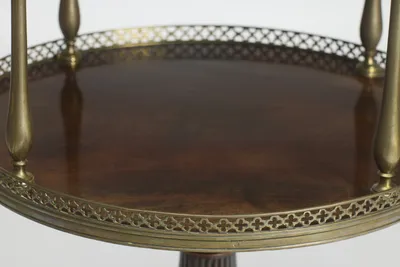 Strongly figured grain across the lower surface, ringed by the quatrefoil gallery where the baluster uprights meet the tier.