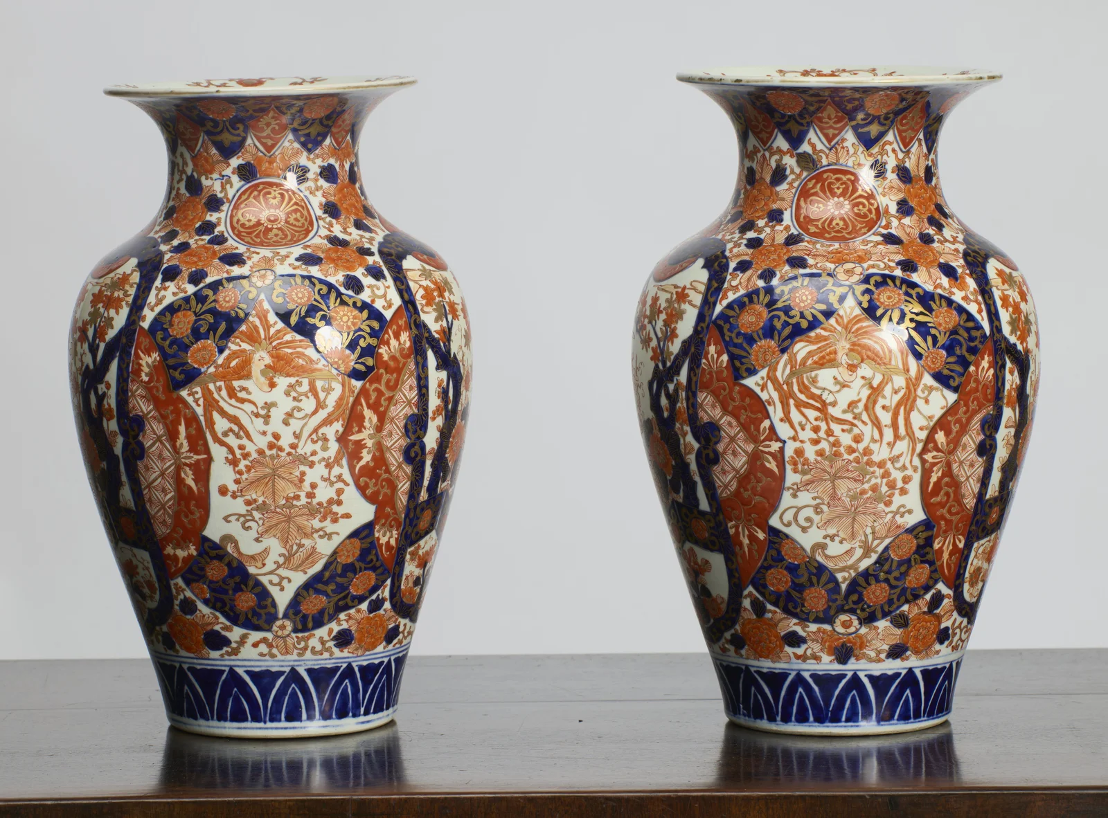The opposite face of each vase, with long-tailed birds painted in iron-red and gilt within shaped panels, beneath a round floral medallion on the neck.