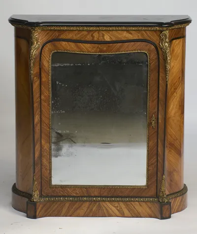 The full serpentine front, its heavily foxed mirror plate framed in gilt beading beneath the moulded ebonised top.