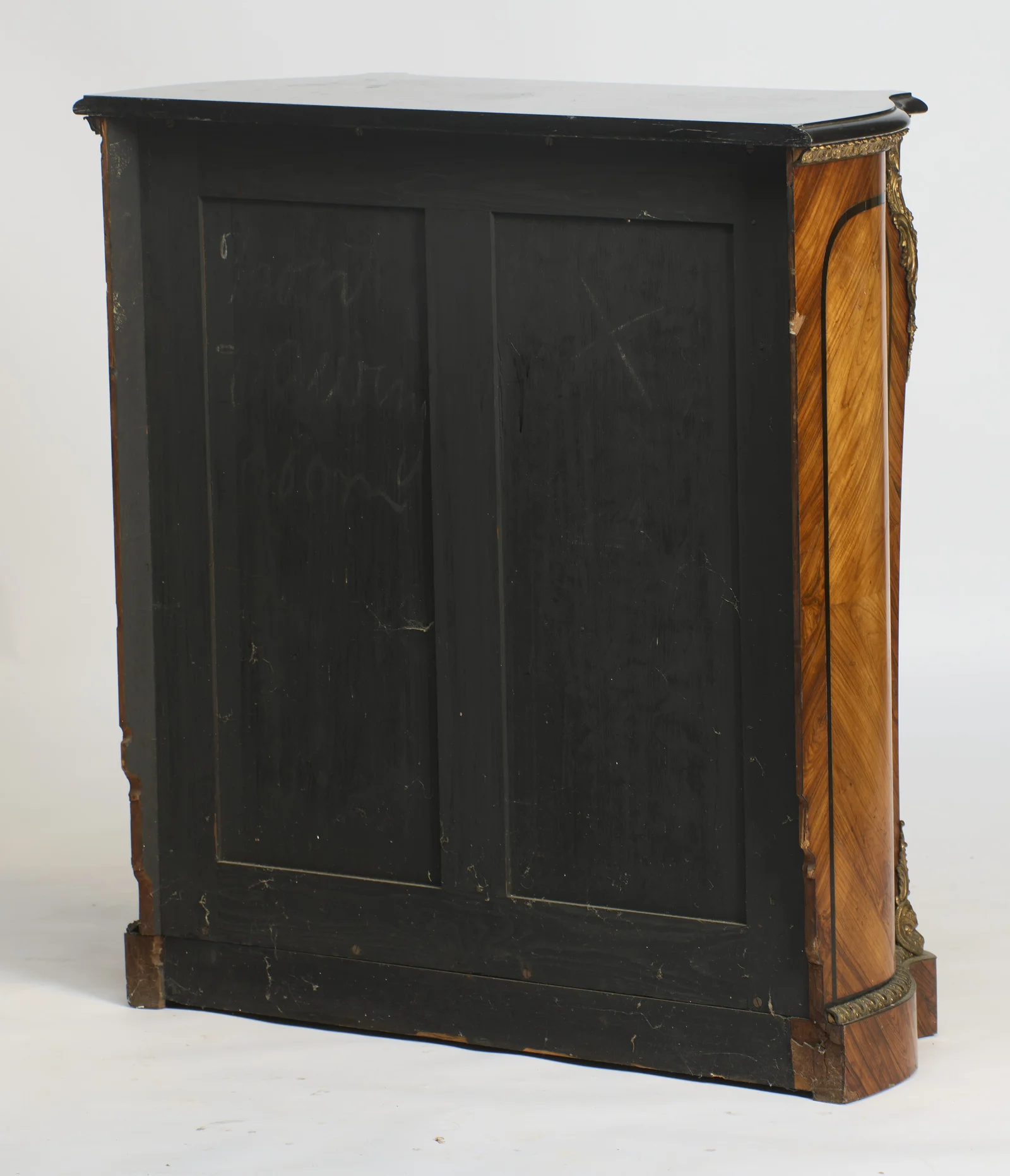 A faint cursive chalk inscription runs across the back panels, and veneer losses show at the rear edge of the end.