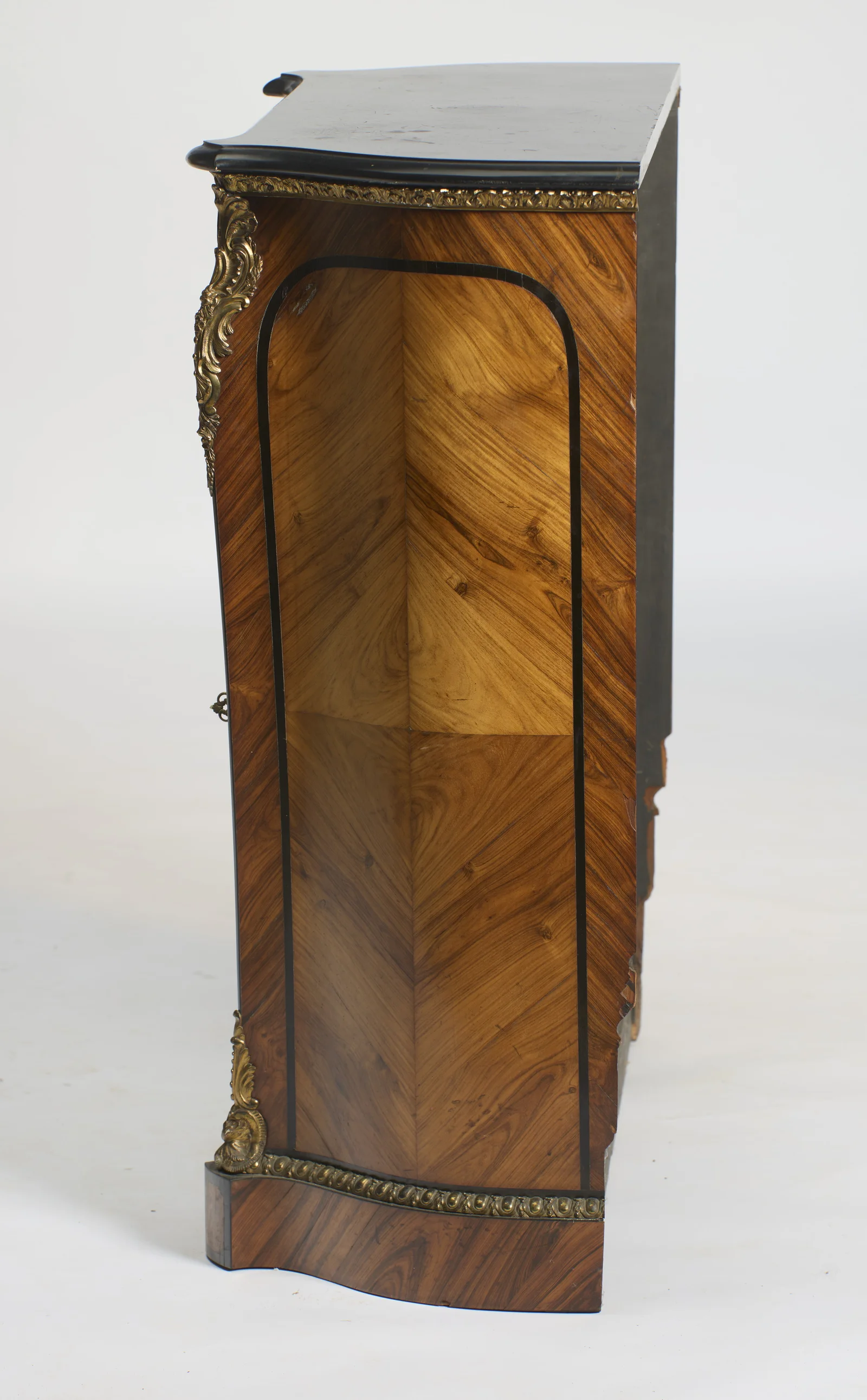 The same shaped panel treatment, with veneer and banding losses visible along the rear edge.
