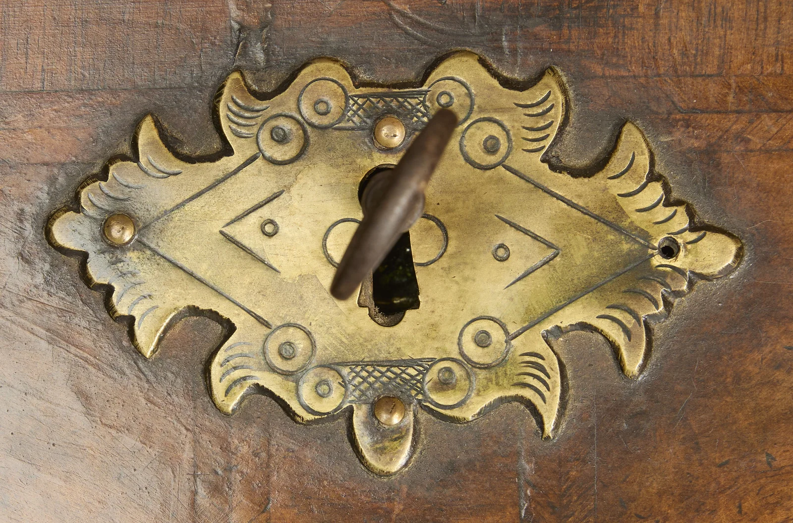 Shaped engraved gilt-metal escutcheon with its key, set on burr veneer within feather-banded borders.