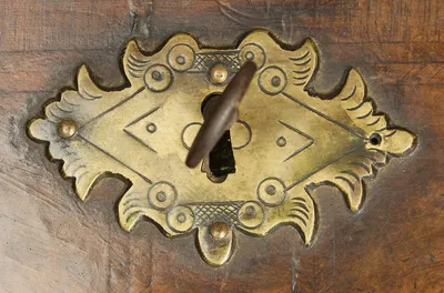 Shaped engraved gilt-metal escutcheon with its key, set on burr veneer within feather-banded borders.