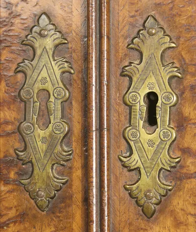 A pair of engraved lozenge escutcheons on the meeting stiles, the mirror plates either side heavily spotted with age.