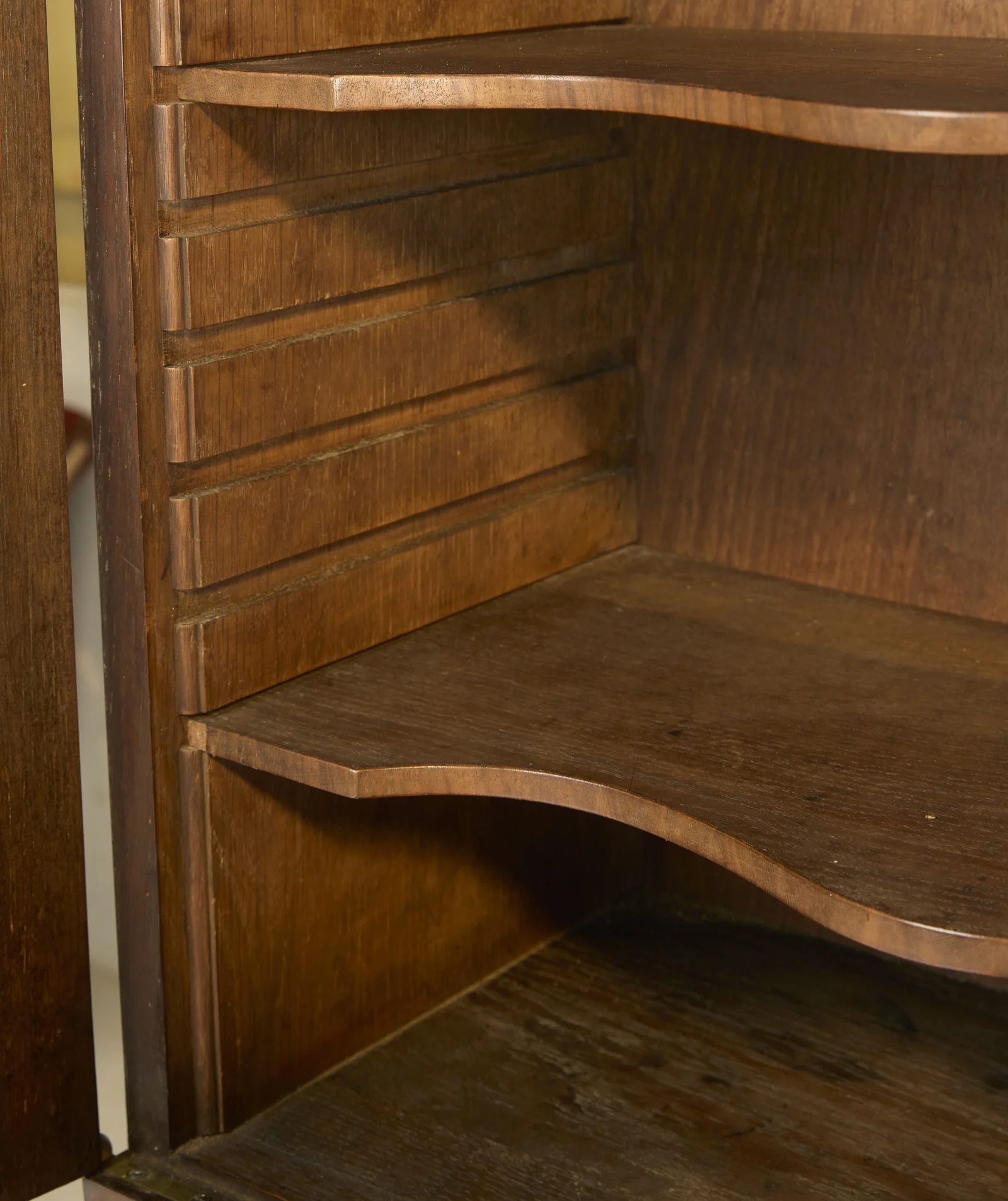 Shaped shelves resting on toothed side supports inside the upper cabinet, cut to sit at different heights.